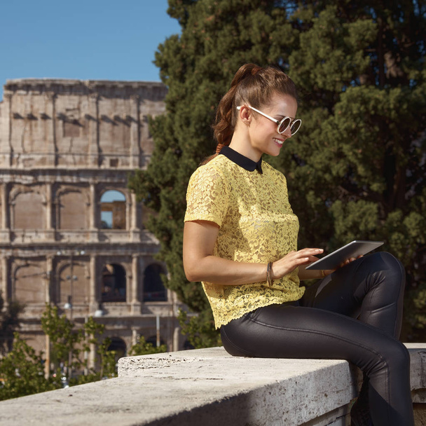 happy stylish woman in yellow blouse and sunglasses using tablet PC near Colosseum , Rome, Italy - Фото, зображення