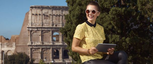 happy stylish woman in yellow blouse with tablet PC near Colosseum , Rome, Italy - Фото, зображення