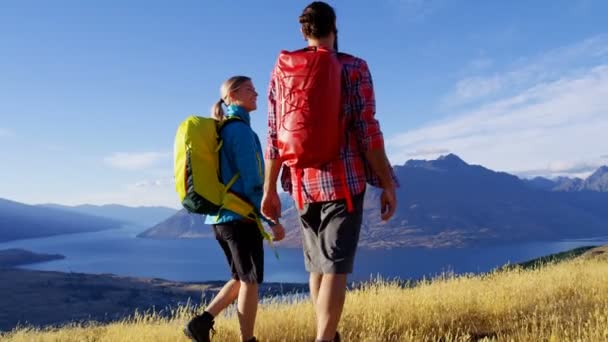 Młodych turystów Kaukaska z plecaków, ciesząc się trekking w puszczy w The Remarkables jezioro Wakatipu Nowej Zelandii  - Materiał filmowy, wideo