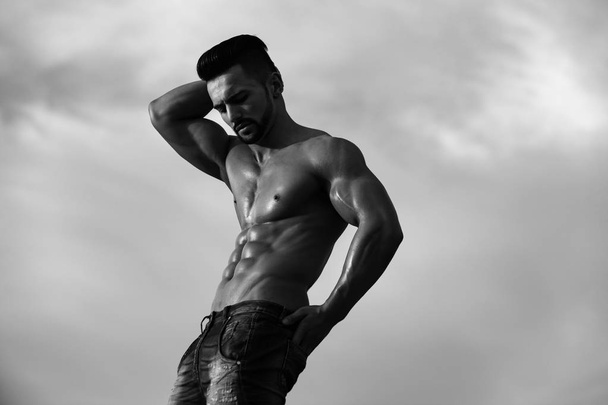sexy man with muscular body on blue sky - Foto, afbeelding