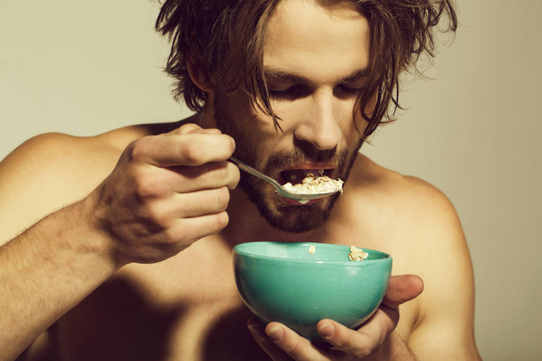 spoon with oatmeal breakfast cereal, healthy food for man or sport athlete on grey background - Foto, afbeelding