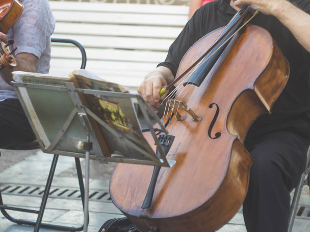 violonchelista grupo de músicos realizar música en la calle, primer plano hombre tocando el violín
 - Foto, imagen