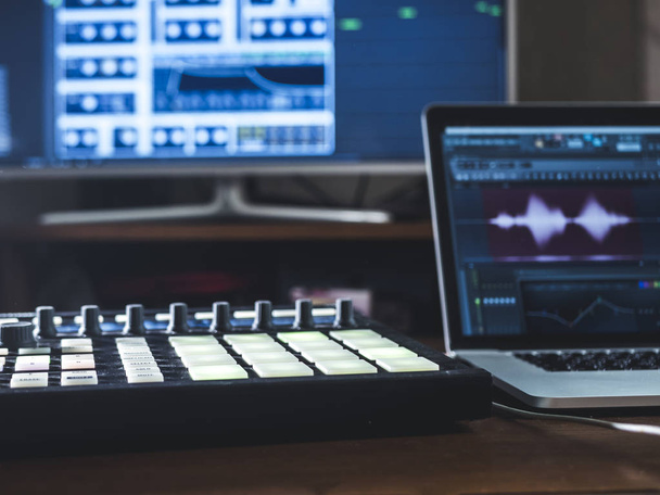 Detailní záběr hudební stroj s podložky na stůl zvukové práce místo s notebookem a externí monitor - Fotografie, Obrázek