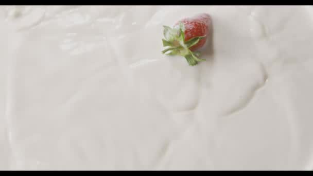 fresh ripe strawberries falling into milk, video  - Záběry, video