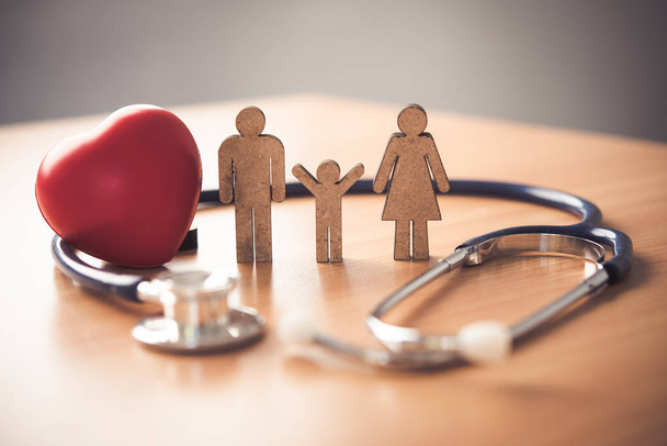 Concept d'assurance médicale avec famille et stéthoscope sur bureau en bois - Photo, image