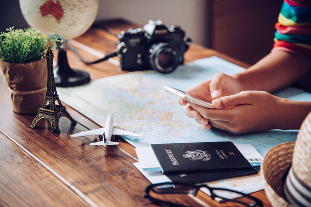 Reisende planen eine Reise, indem sie die Route auf der Karte suchen und im Internet nach Informationen suchen.. - Foto, Bild