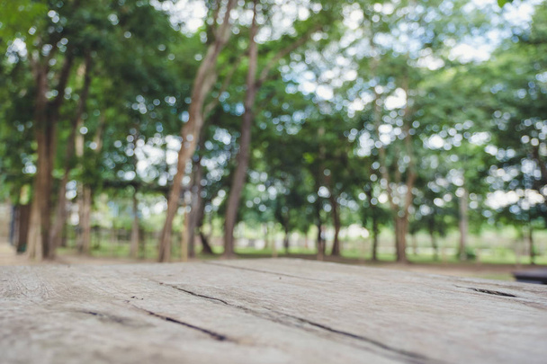 Closeup bulanıklık ağaç arka planda ile ahşap bir masa görüntü - Fotoğraf, Görsel