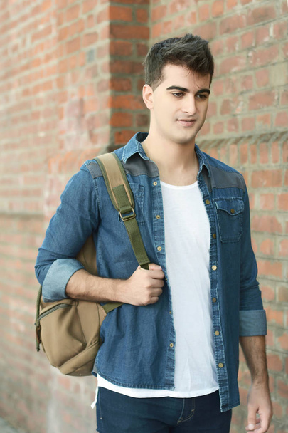 Young man walking down the street with a backpack. Outdoors - Photo, Image