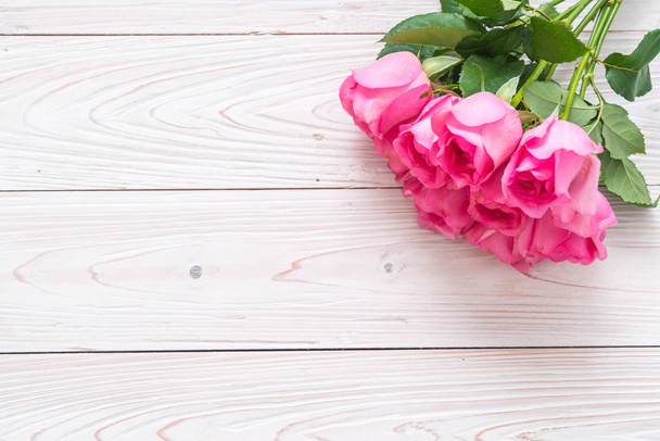pink rose in vase on wood background with copy space - Φωτογραφία, εικόνα