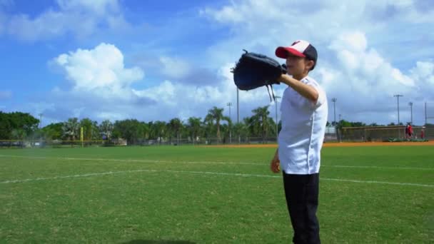 Daytime câmera lenta de um menino pegando e jogando beisebol no parque durante o treino
 - Filmagem, Vídeo