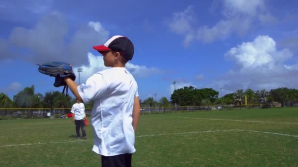 Повільний рух дітей кидає і ловить м'ячі під час бейсбольної практики в парку
 - Кадри, відео