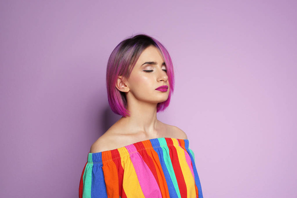 Young woman with trendy hairstyle against color background - Foto, immagini