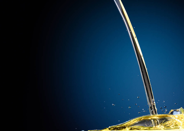Close-up of oil and liquid pouring on dark background. - 写真・画像