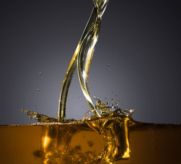 Close-up of oil and liquid pouring on dark background. - Foto, Imagem