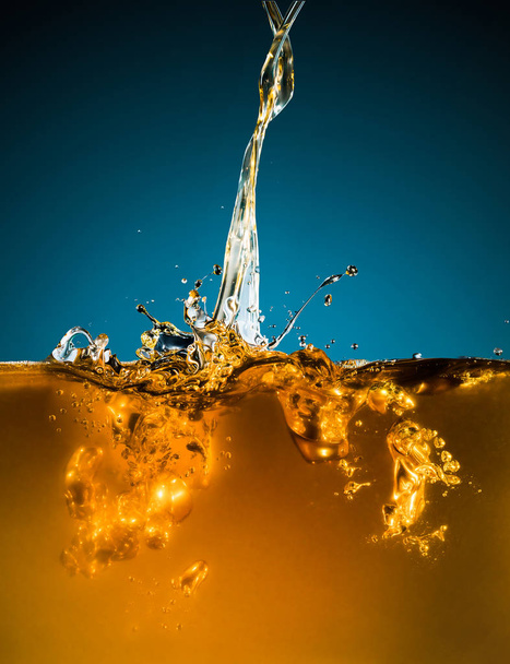 Close-up of oil and liquid pouring on dark background. - Φωτογραφία, εικόνα