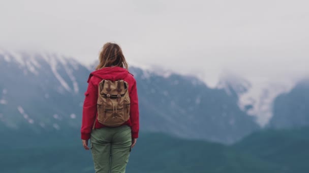 muotokuva tytöstä, jolla on reppu vuorilla matkustamiseen
 - Materiaali, video