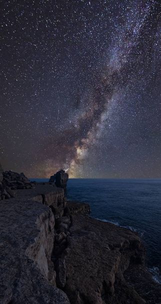Impressionante vibrante Via Láctea imagem composta sobre a paisagem de penhasco rochoso sobre o oceano
 - Foto, Imagem