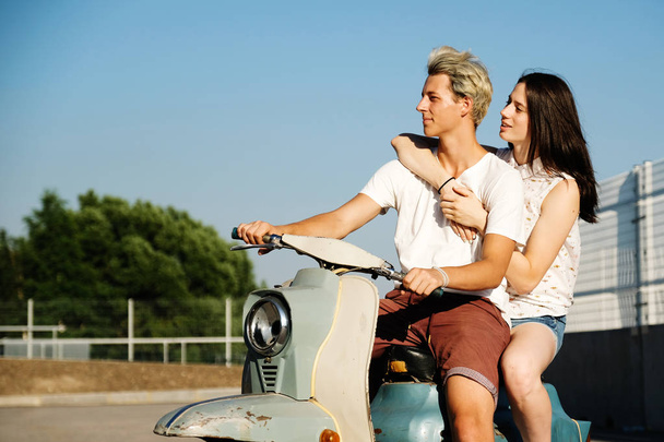 young beautiful couple in love riding on old scooter. adventure and vacations concept. motorbike, summer, traveling, romance, smiling, happy, having fun, stylish outfit, date, enjoying in trip - Photo, image