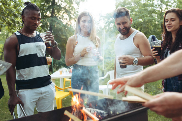 Group of friends making barbecue in the backyard. concept about good and positive mood with friends - Фото, изображение