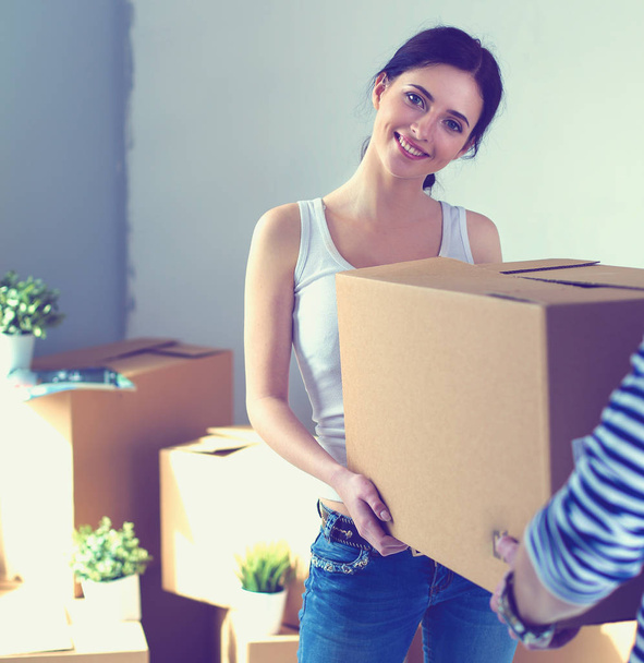 Happy young couple unpacking or packing boxes and moving into a new home. young couple - Photo, image
