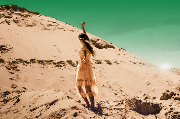young brunette girl in pink dress in desert - Photo, Image