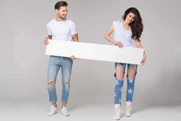 Happy summer couple with white board - Fotoğraf, Görsel