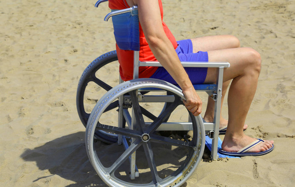 hombre con silla de ruedas especial en la playa en verano
 - Foto, Imagen