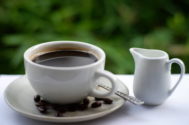 filiżanka kawy i ziarna kawy na starym drewnianym tle stołu, miejsce na tekst - Zdjęcie, obraz