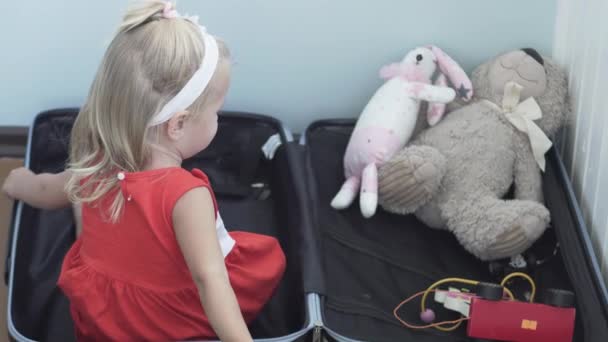 маленька дівчинка збирає валізу у відпустці
 - Кадри, відео