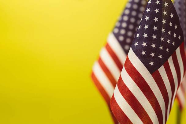Flagi Stanów Zjednoczonych z żółtym tle pustej przestrzeni tekstu po lewej stronie. - Zdjęcie, obraz