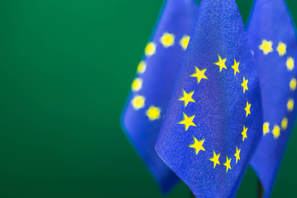 Σημαίες της ενωμένης Ευρώπης με πράσινο φόντο κενό χώρο για το κείμενό σας στα αριστερά. - Φωτογραφία, εικόνα