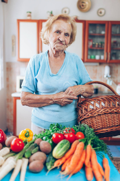 Happy senior woman at home with fresh crop from her garden - Fotoğraf, Görsel