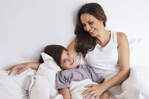 Смеющиеся мама и ребенок в постели, улыбающиеся
 - Фото, изображение