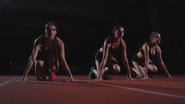 Vrouwelijke atleten warming-up op de atletiekbaan voor een race. In slow motion - Video