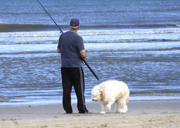 άνθρωπος σερφ, ψάρεμα με σκύλο - Φωτογραφία, εικόνα