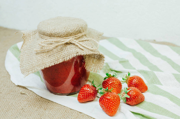 Frasco de compota de morango vermelho na mesa
 - Foto, Imagem