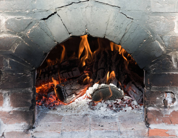 Gros plan du four à briques avec un feu rugissant
 - Photo, image