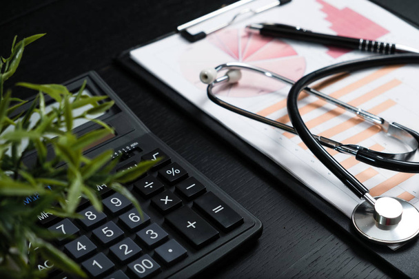 Estetoscópio e calculadora símbolo para custos de cuidados de saúde ou seguro médico
 - Foto, Imagem