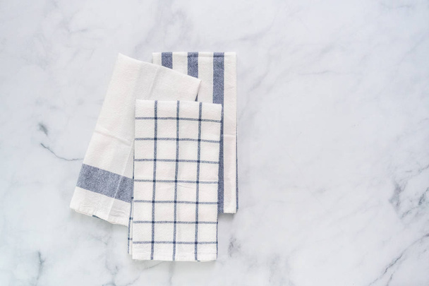 Nuovi asciugamani da cucina con semplice motivo blu piegato sul bancone in marmo
. - Foto, immagini