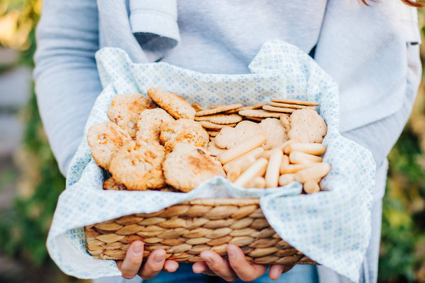 Sommerpicknick. Korb mit Lebensmitteln in der Hand. süße Desserts. - Foto, Bild