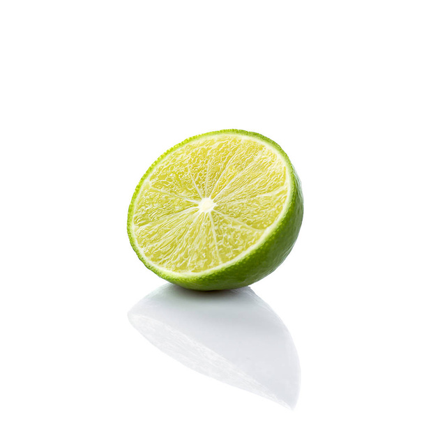 Half of lime citrus fruit (lime cut) isolated on white background. Sliced lime half with clipping path - Photo, Image