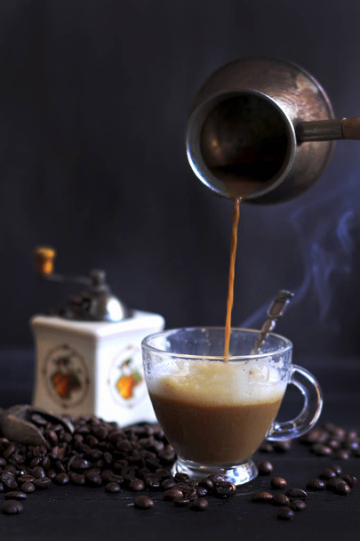 Zubereitung von aromatischem Kaffee mit Schaum und Milch. dunkles Foto. türkischer Kaffee. Kopie spce - Foto, Bild