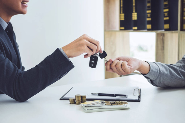 Salesman send key to customer after good deal agreement, successful car loan contract buying or selling new vehicle. - Zdjęcie, obraz