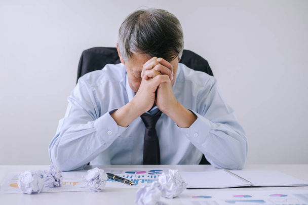 Czuje się chory i zmęczony, starszy biznesmen w depresji i wyczerpany, biznesmen przy biurku sfrustrowany problemy z kupą pracy i utrzymanie oczy zamknięte siedząc w biurze. - Zdjęcie, obraz