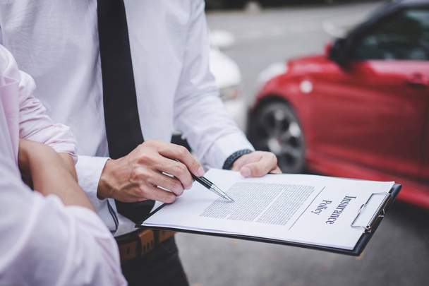 Insurance Agent examine Damaged Car and customer filing signature on Report Claim Form process after accident, Traffic Accident and insurance concept. - Foto, imagen