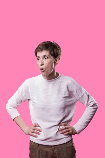 Ух ты. Женский портрет в пол-длины, изолированный на розовом заднем плане студии
. - Фото, изображение