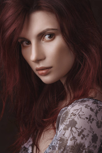Dramatic retro portrait of a young beautiful dreamy redhead woman. Soft vintage toning - Фото, изображение