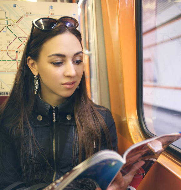 Indian or arabic woman reading magazine in subway - Фото, зображення
