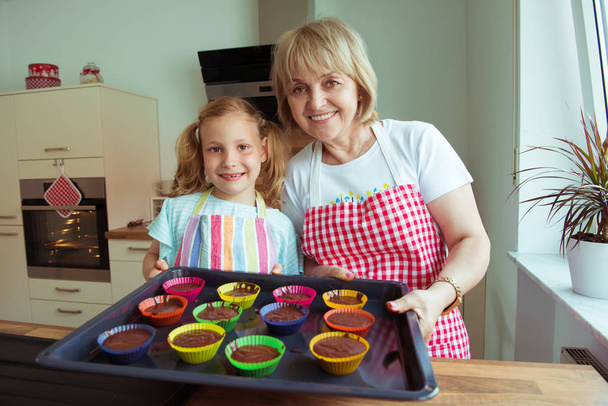 Boldog szép nagymama és unokái, modern konyha, szórakozás, sütés közben portréja - Fotó, kép