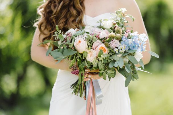 Bride holding flowers for wedding photoshoot - Foto, afbeelding